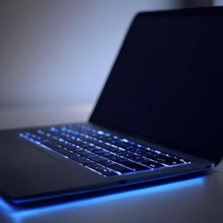 Smukły laptop z podświetlaną klawiaturą na ciemnym tle