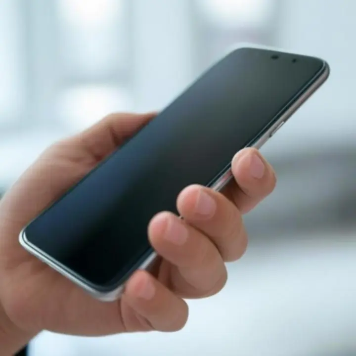 Smartfon trzymany w dłoni, prezentujący ekran i elegancki design